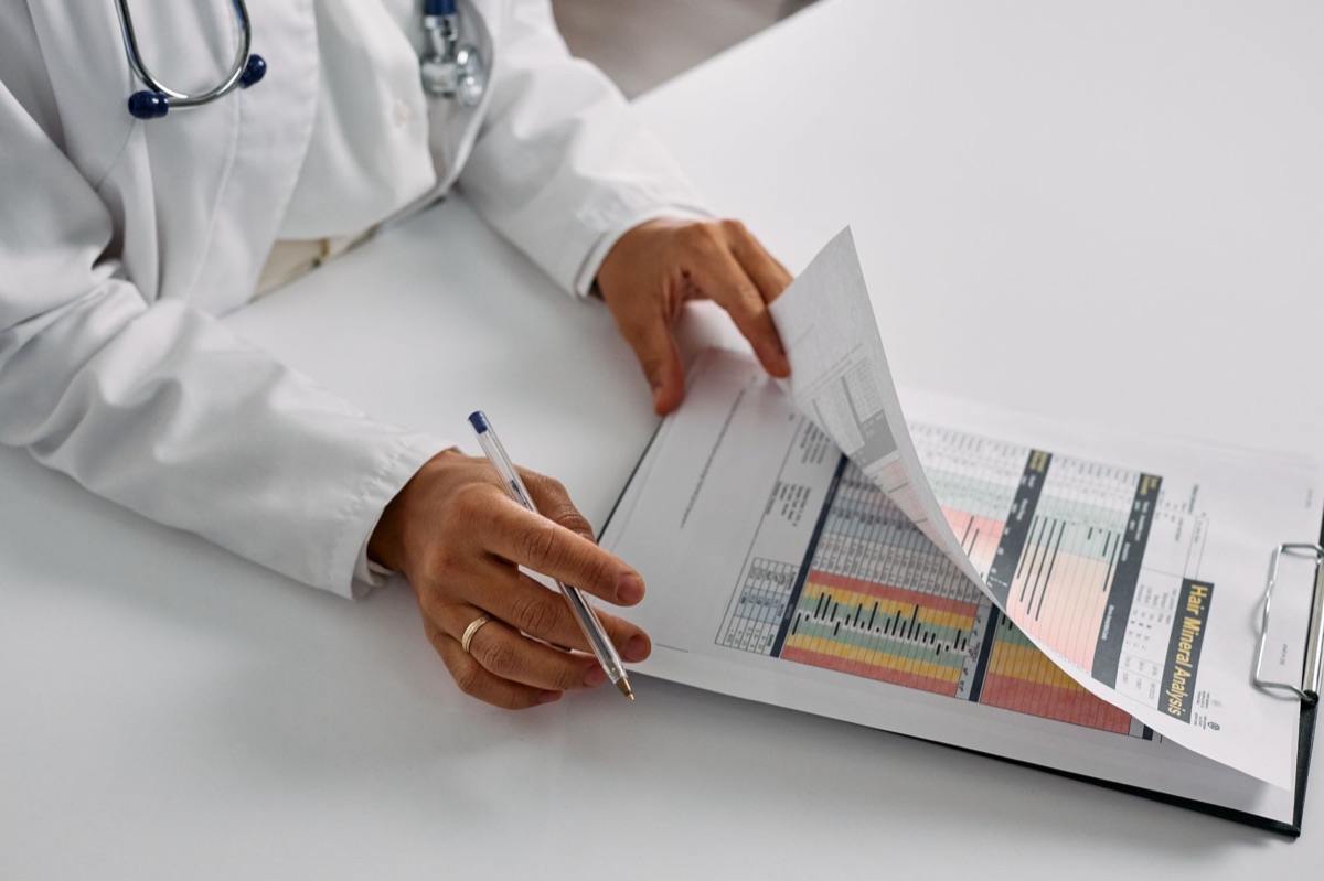 A hand holding a paper growth chart showing percentiles.
