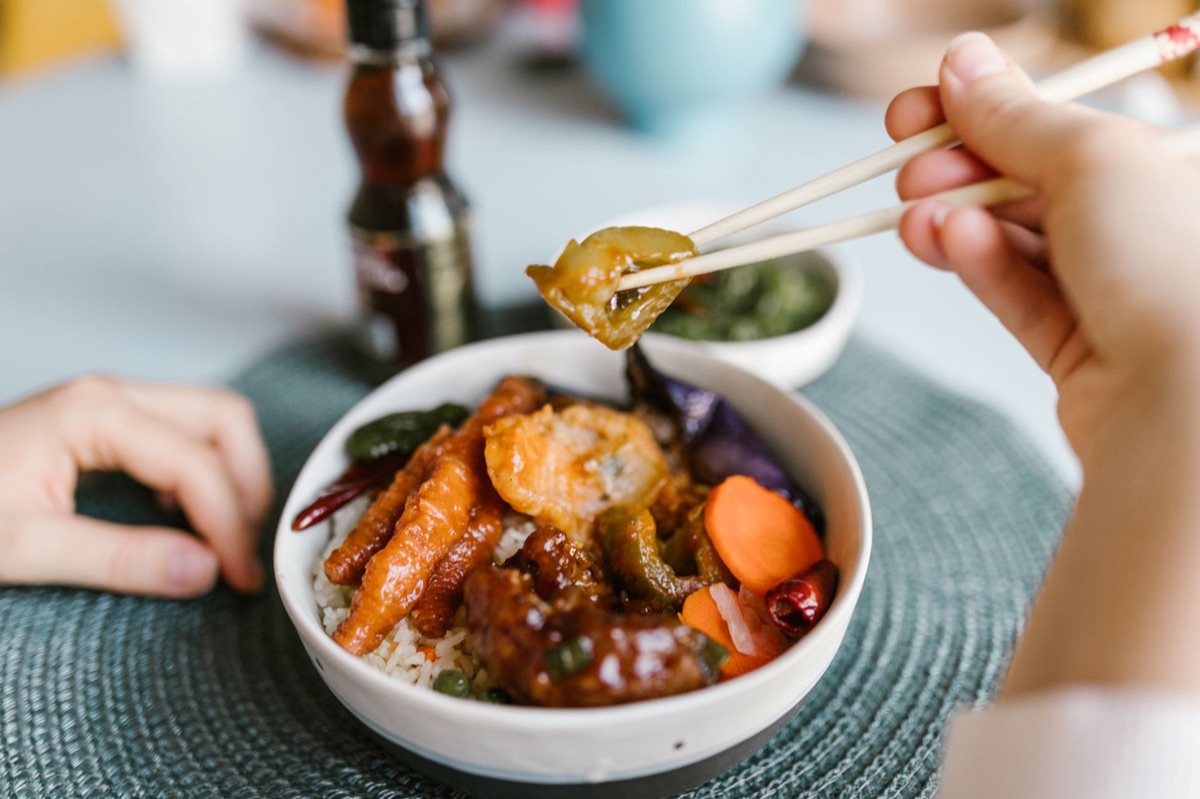 person cooking vegetable stir-fry with soy sauce and ginger