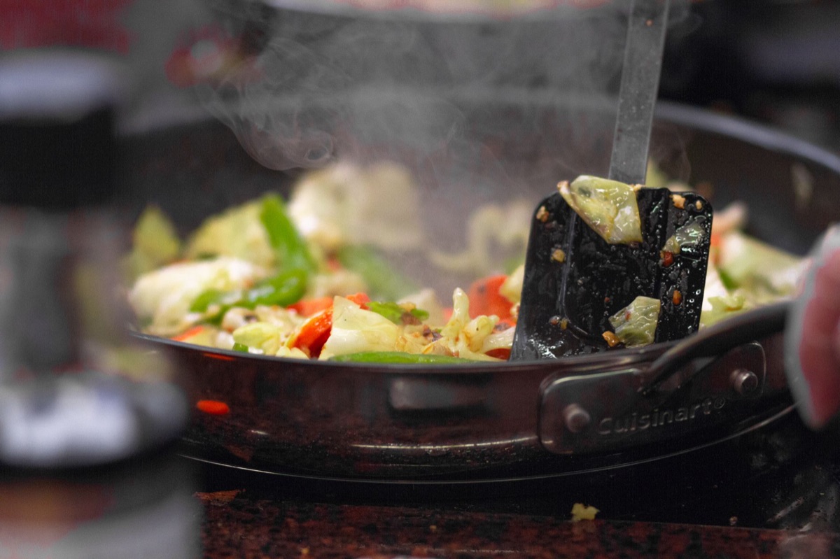 persona che cuoce un insalata di verdure con salsa di soia e ginger