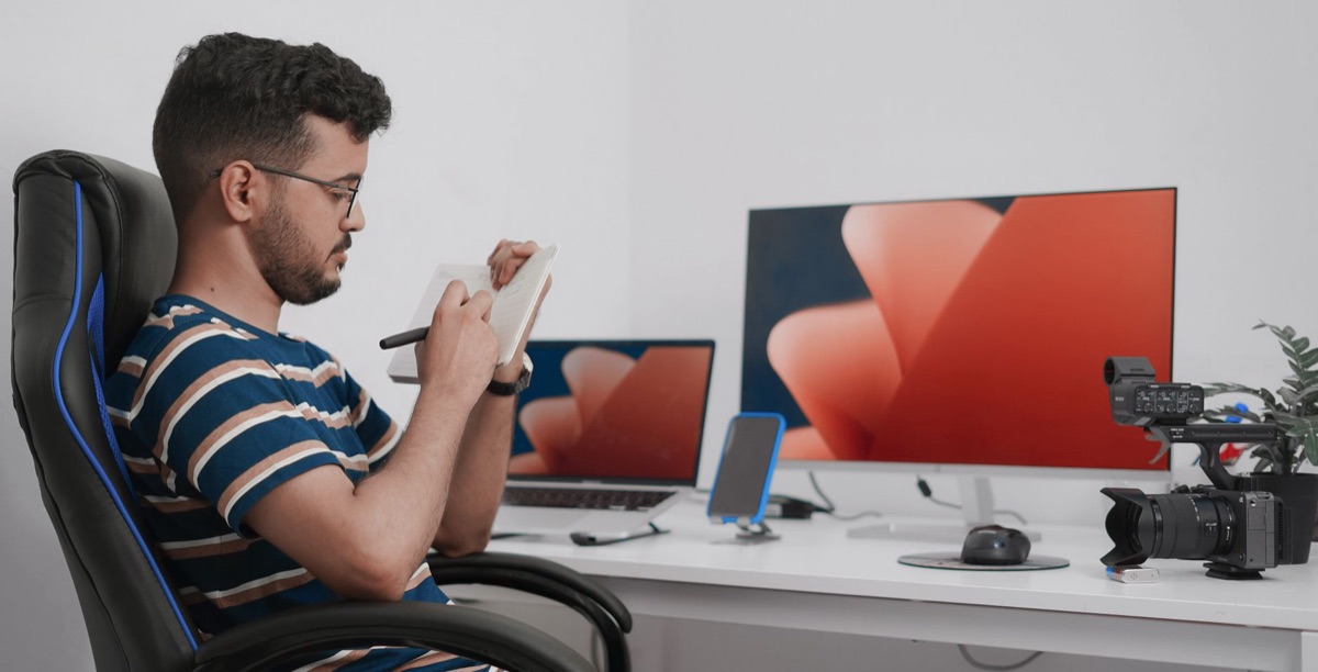 una persona scrive i pasti su un quaderno con una bilancia digitale