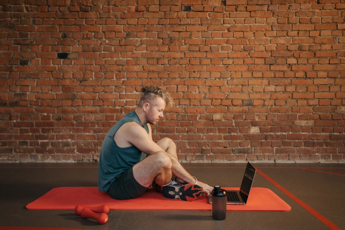Person mit Fitness-Tagebuch und Trainingsplan