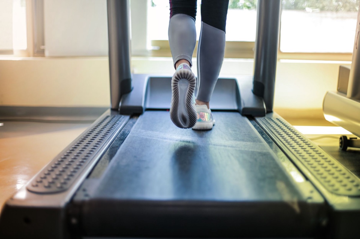 Une personne sur une machine à course dans un gym