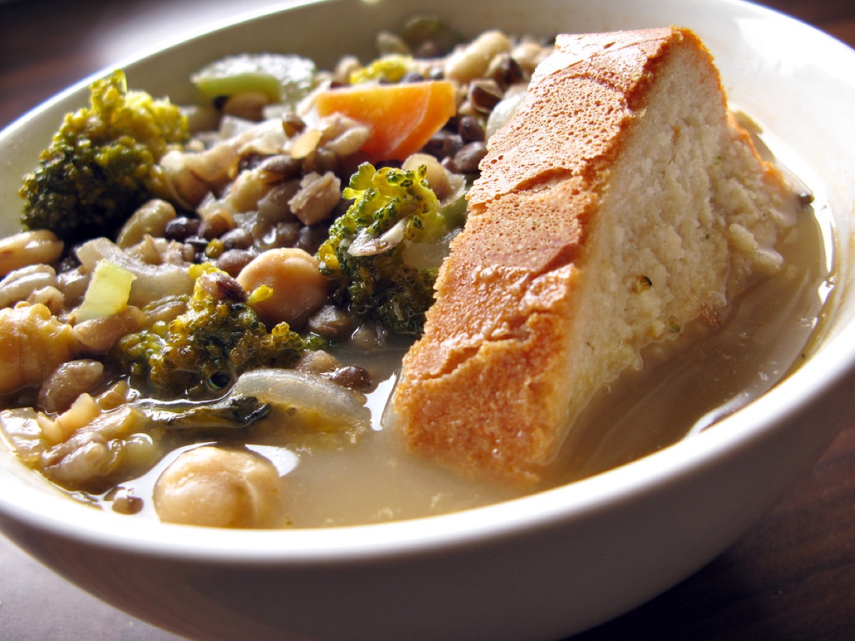 A bowl of hearty lentil soup with fresh vegetables.